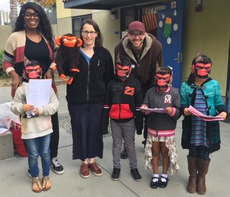 Suzanne and Max Lang with puppet, volunteer, and kids at MacArthur Park Elementary